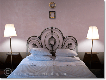 Vintage pink bedroom walls with wrought-iron headboard