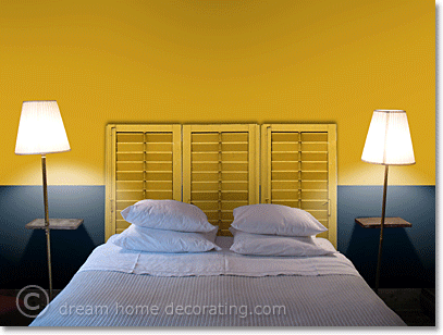 Yellow bedroom walls with yellow wooden shutters as a headboard