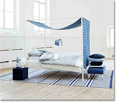 Skandinavian bedroom with canopy bed, covered in blue and white fabrics