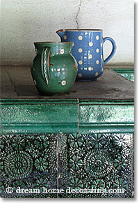 country decorating: rustic ceramic jugs on a Swiss tiled oven