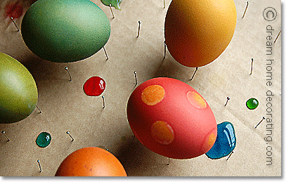 freshly dyed easter eggs on a drying rack made of pins and cardboard