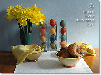 Hand-dyed Easter eggs in narrow glass vases: Centerpiece on a yellow/white Easter table