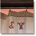 antique linen sheet with red monogram, used as a window curtain