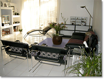 white living room with purple rug and black furniture