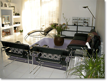 white living room with purple rug and black furniture