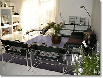 white living room with large purple rug and black furniture