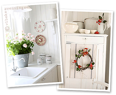 white Norwegian kitchen and free-standing white wooden cupboard with a red berry wreath