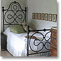 Traditional Tuscan bedroom with a black wrought-iron bedstead
