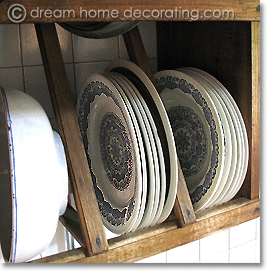 blue and white transferware plates in a wooden dish rack