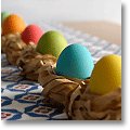 dyed duck eggs in paper easter nests lined up on an Easter breakfast table