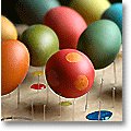 Freshly dyed Easter eggs on a drying rack.