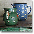 dotted ceramic jugs on a tiled oven