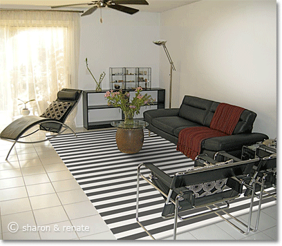 White Arizona living room with black furniture and a black-and-white striped area rug