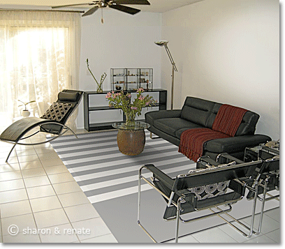 White Arizona living room with black furniture and a grey-and-white striped area rug