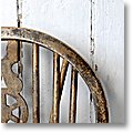 old windsor chair back in front of a white wall (detail)