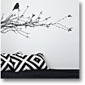 Norwegian black sofa with black-and-white cushions and a blackbird wall decal