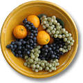 ochre colored earthenware bowl with grapes and oranges