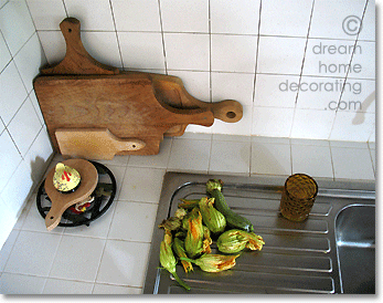 Tuscan kitchen worktop with cutting boards and courgette flowers