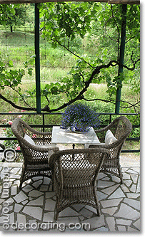 marble top bistro table and wicker chairs on a terrace, Tuscany, Italy