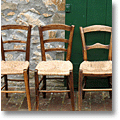 Tuscan straw-seated chairs in front of a podere